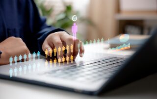 HR Manager with digital icons of people and a pie chart above a laptop