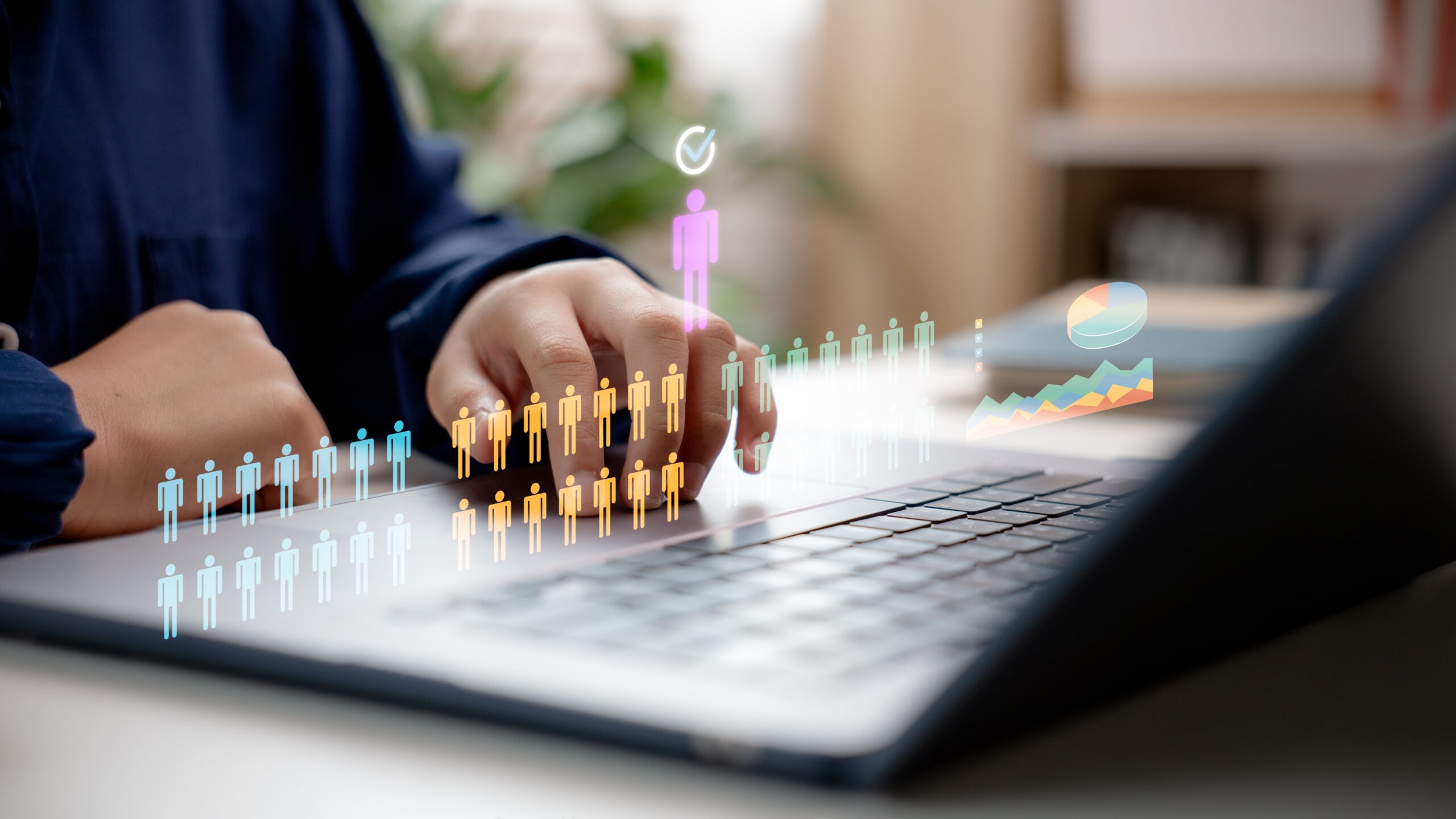 HR Manager with digital icons of people and a pie chart above a laptop