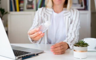 Businesswoman at a desk with hand sanitiser to help protect against Covid-19