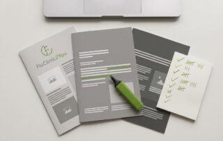 Corporate brochures and highlighter pen on an office desk, representing the process of comparing corporate flu vaccination providers in the UK